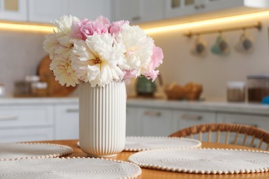 Photo of Beautiful peonies in vase on table indoors, space for text