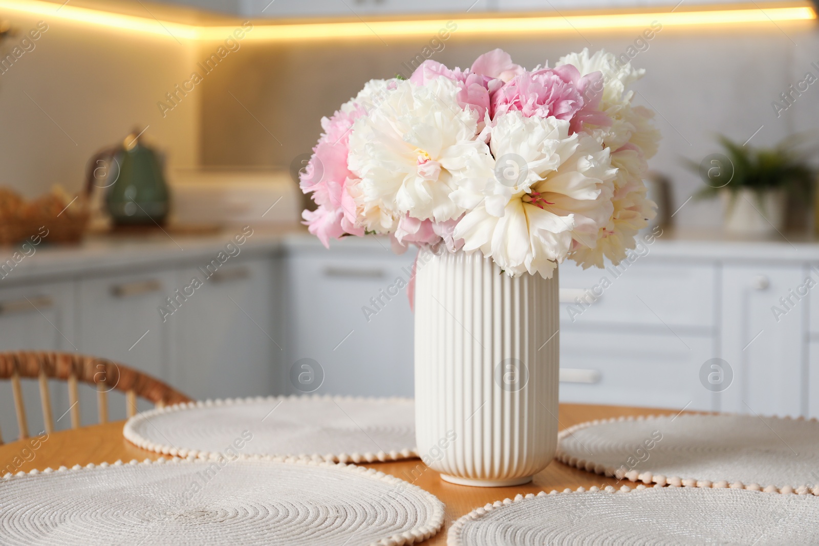 Beautiful peonies in vase on table indoors, space for text Photo of Beautiful peonies in vase on table indoors, space for text