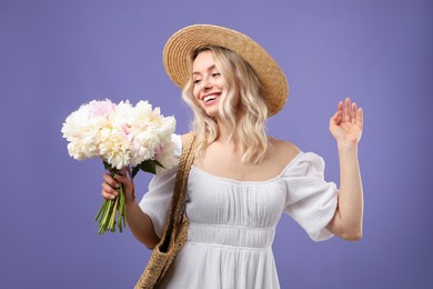 Photo of Happy woman with bouquet of beautiful peonies on purple background