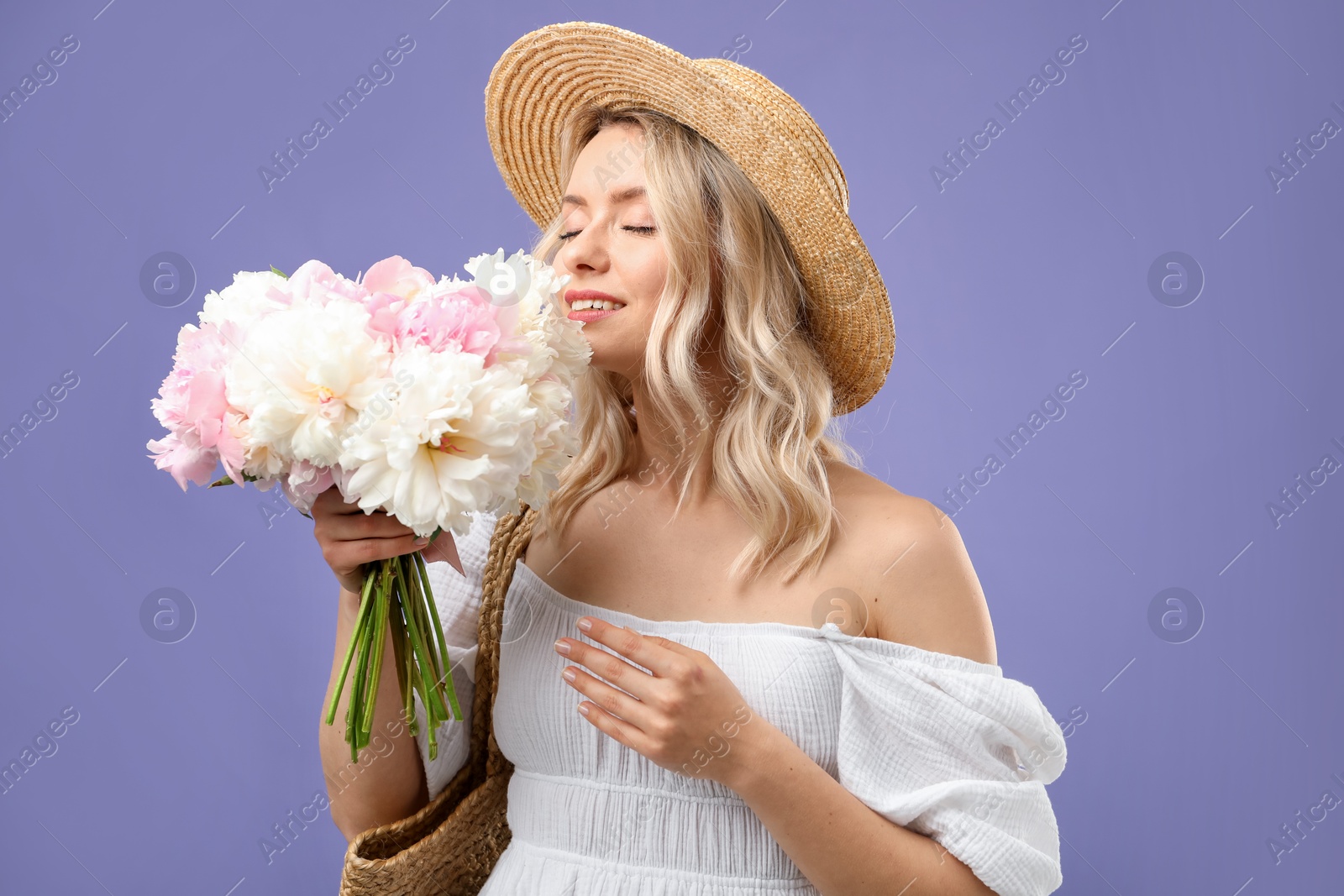 Happy woman with bouquet of beautiful peonies on purple background Photo of Happy woman with bouquet of beautiful peonies on purple background