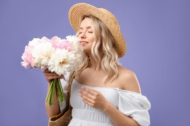 Photo of Happy woman with bouquet of beautiful peonies on purple background