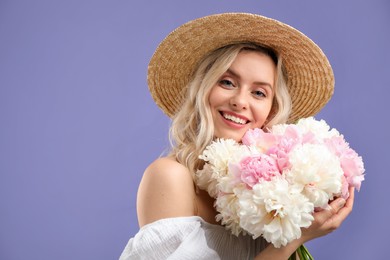 Photo of Happy woman with bouquet of beautiful peonies on purple background