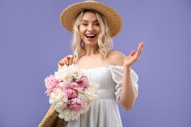 Photo of Happy woman with bouquet of beautiful peonies on purple background