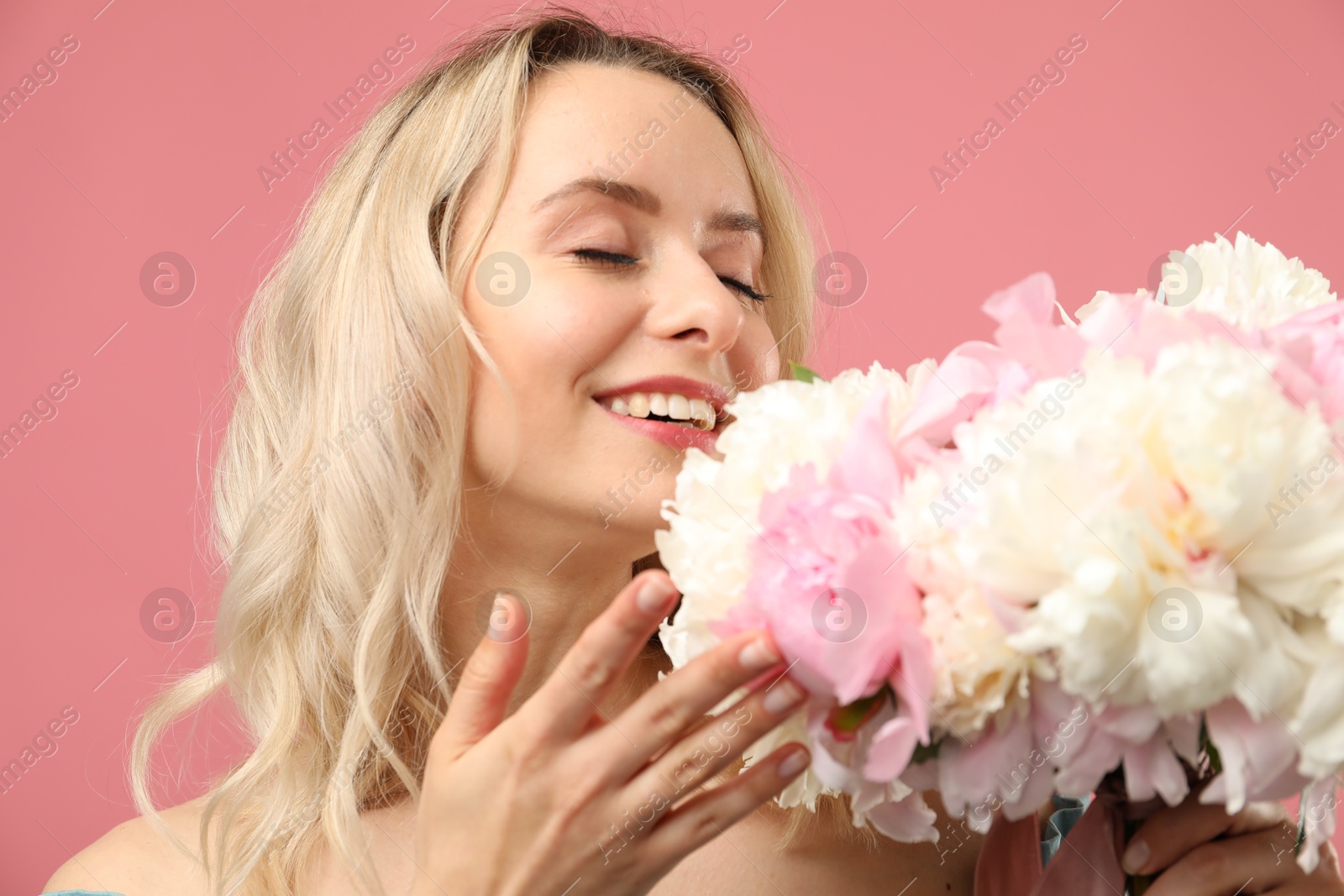 Happy woman with bouquet of beautiful peonies on pink background Photo of Happy woman with bouquet of beautiful peonies on pink background