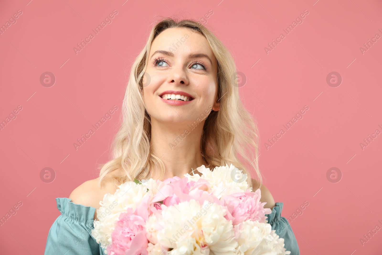 Photo of Happy woman with bouquet of beautiful peonies on pink background