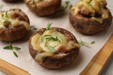 Photo of Delicious stuffed mushrooms with melted cheese and thyme on grey table, closeup