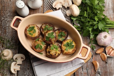 Photo of Delicious stuffed mushrooms in baking dish and products on color wooden table, flat lay