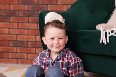 Photo of Little boy with his pet rat at home