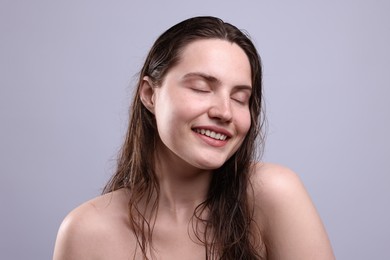 Photo of Smiling woman with natural skin complexion on grey background, closeup