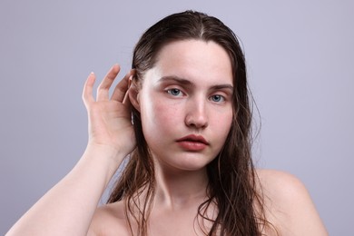 Photo of Portrait of woman with natural skin complexion on grey background, closeup