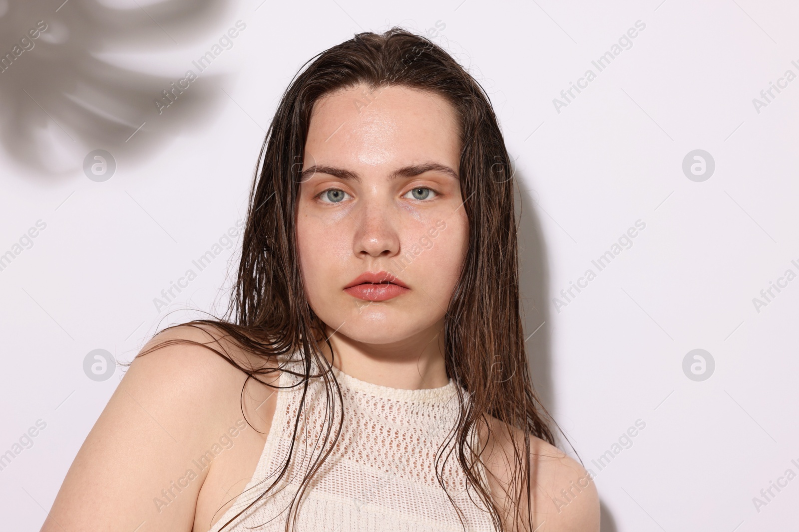 Photo of Portrait of beautiful woman with natural skin complexion on light background with shadows, closeup