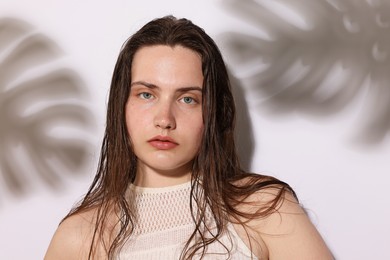 Photo of Portrait of beautiful woman with natural skin complexion on light background with shadows, closeup