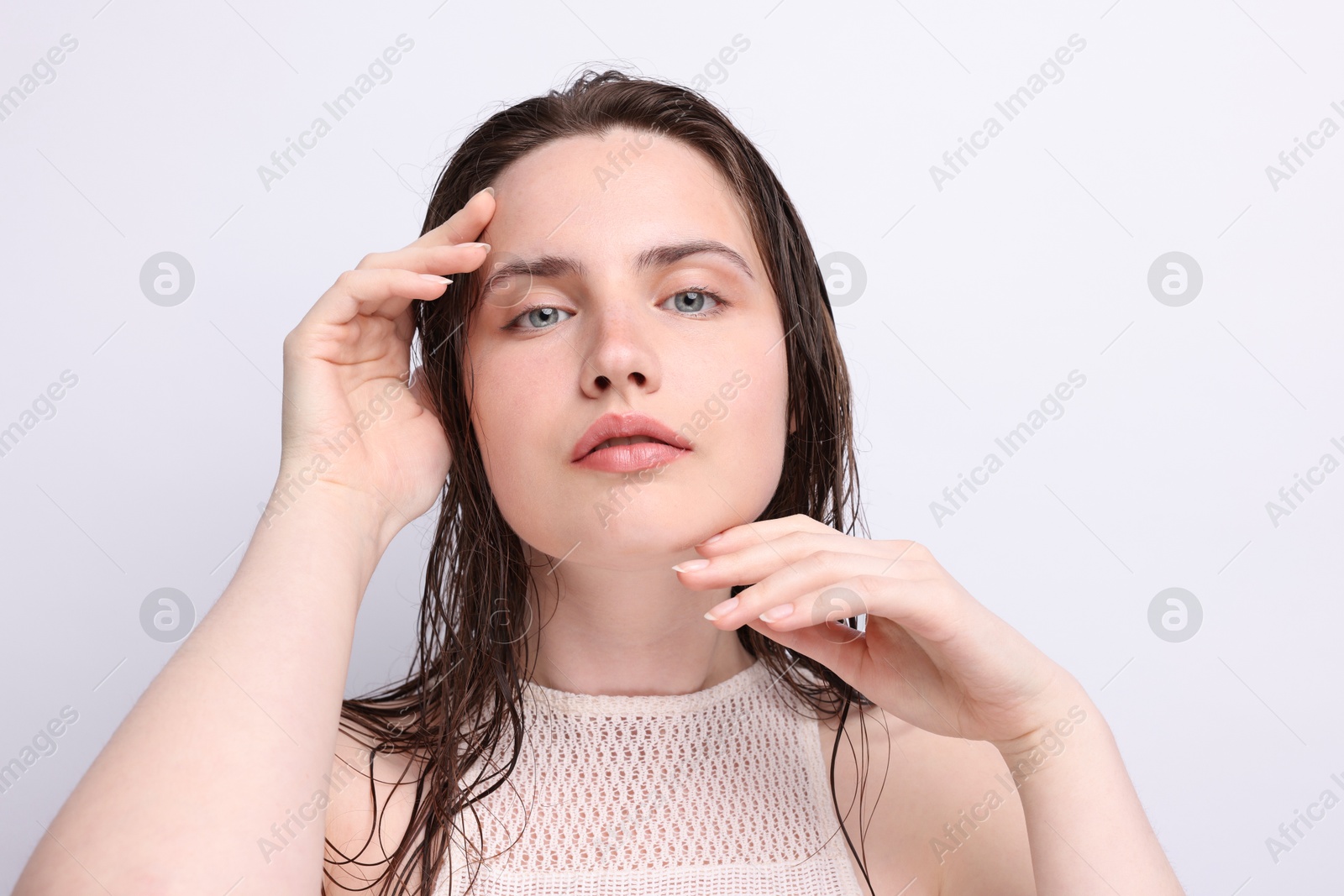 Portrait of beautiful woman with natural skin complexion on light grey background, closeup Photo of Portrait of beautiful woman with natural skin complexion on light grey background, closeup