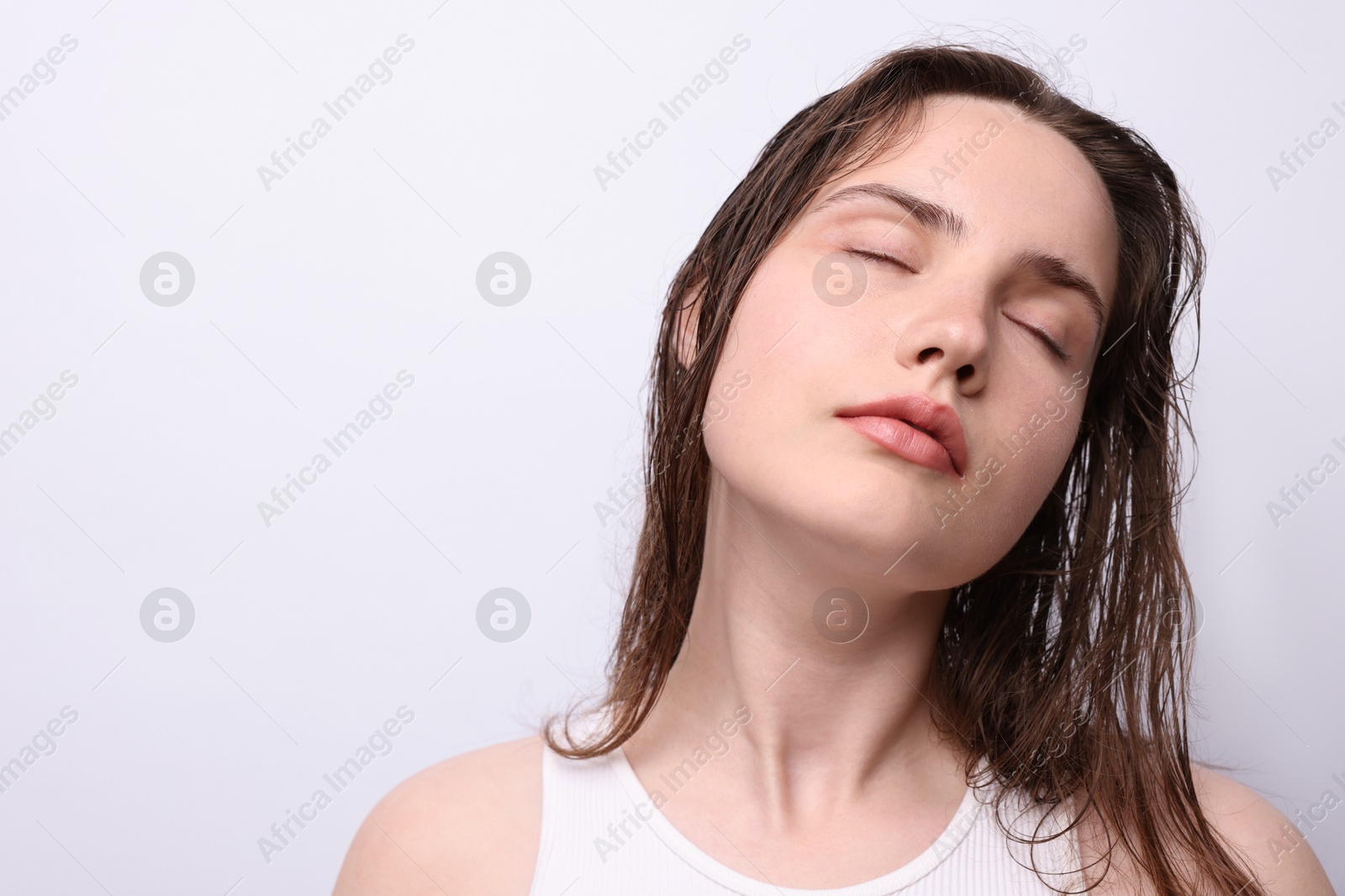 Photo of Beautiful woman with natural skin complexion on light grey background, closeup. Space for text