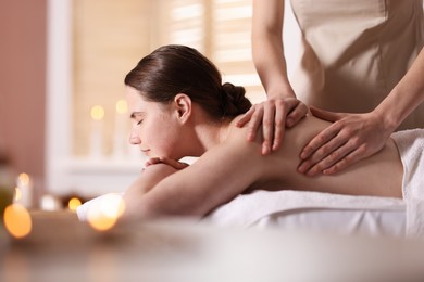 Photo of Woman receiving back massage with oil in spa salon, space for text