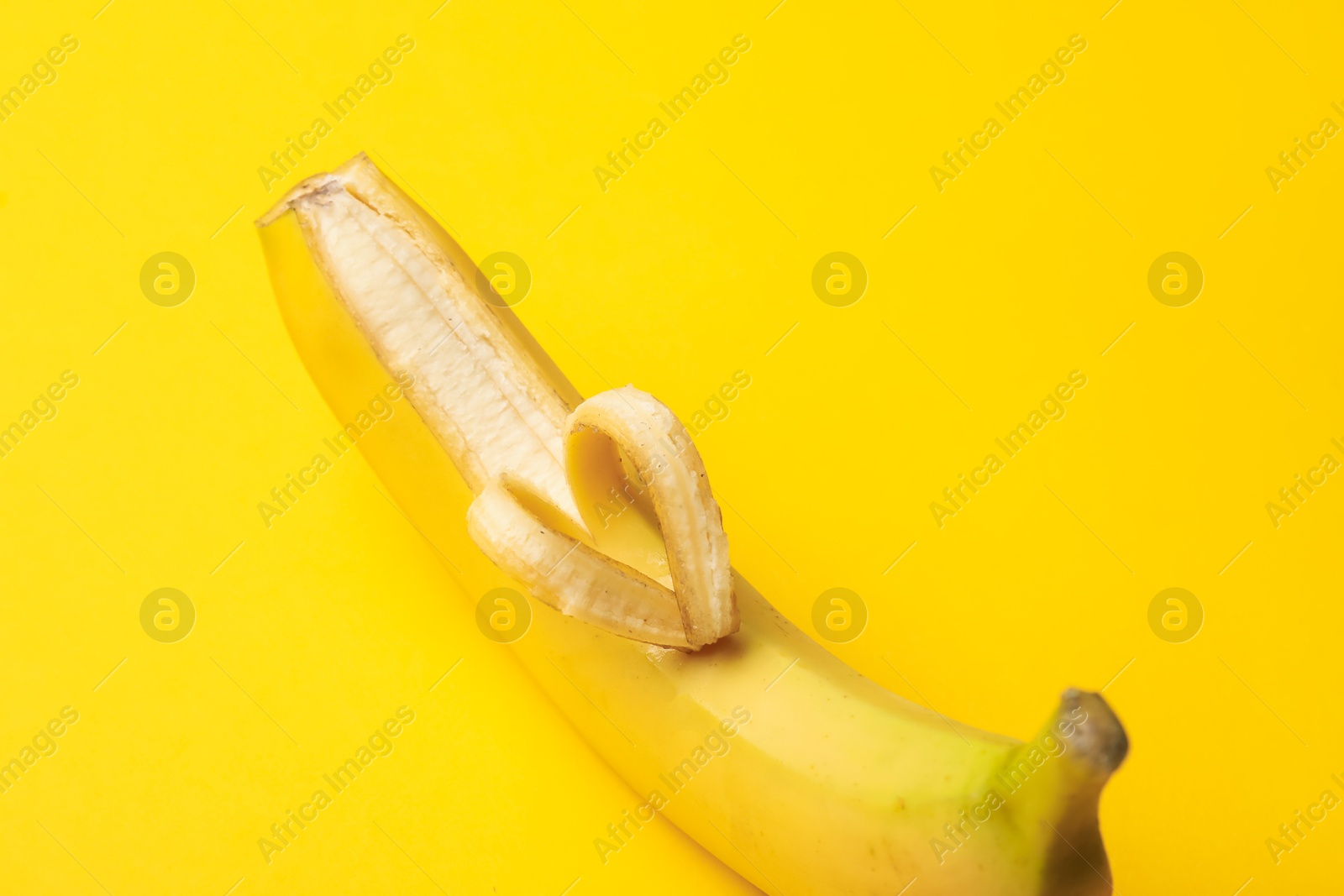 Banana with heart made of peel on yellow background, closeup Photo of Banana with heart made of peel on yellow background, closeup
