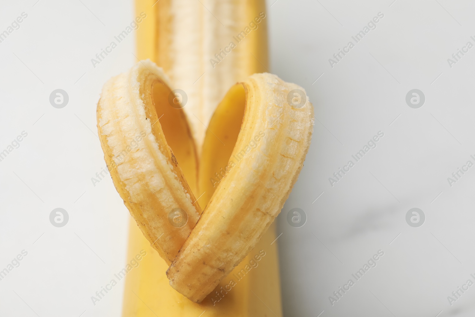 Banana with heart made of peel on white table, closeup Photo of Banana with heart made of peel on white table, closeup