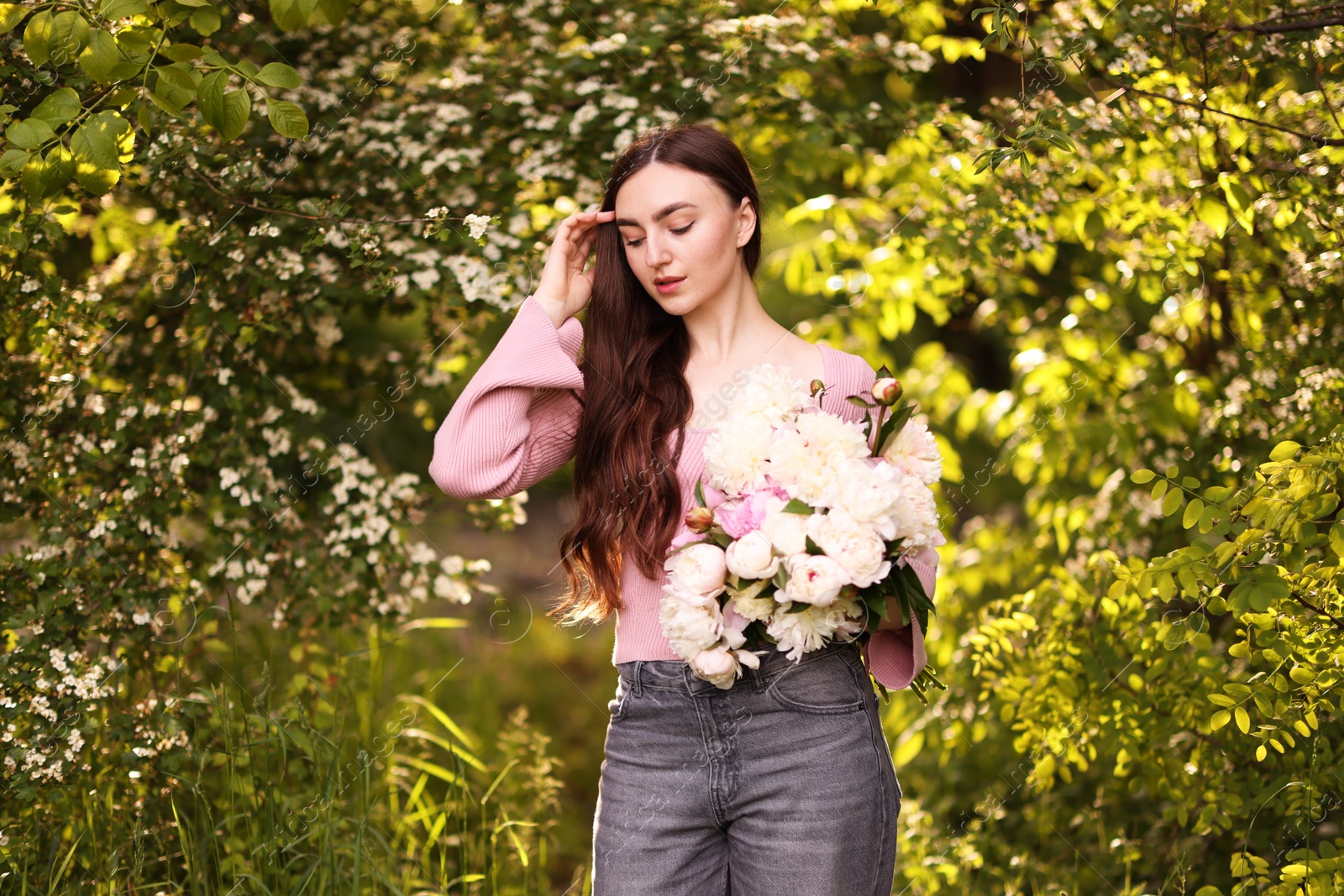 Photo of Beautiful woman with bouquet of peonies in park