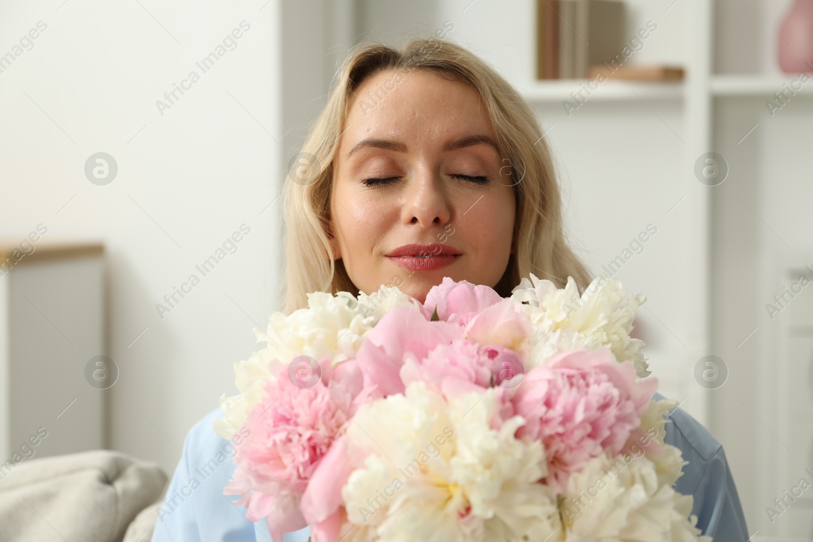 Photo of Woman with bouquet of beautiful peonies at home