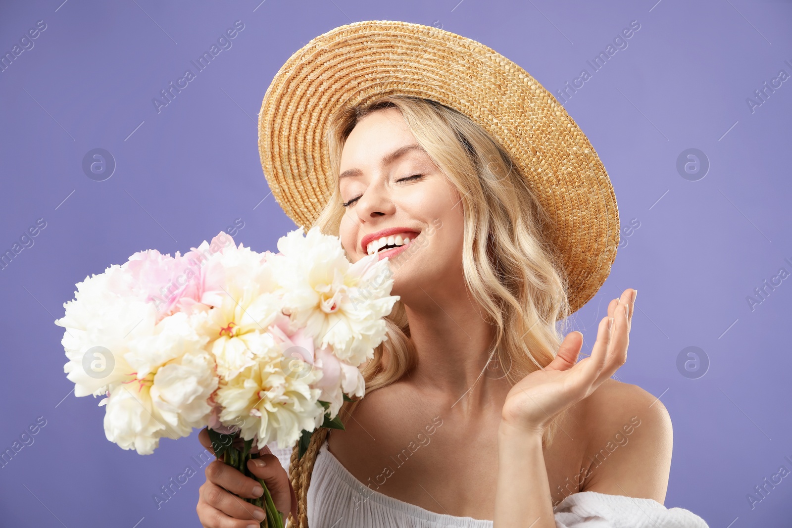Photo of Happy woman with bouquet of beautiful peonies on purple background