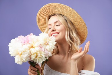 Photo of Happy woman with bouquet of beautiful peonies on purple background