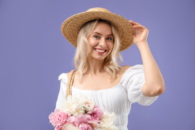 Photo of Happy woman with bouquet of beautiful peonies on purple background