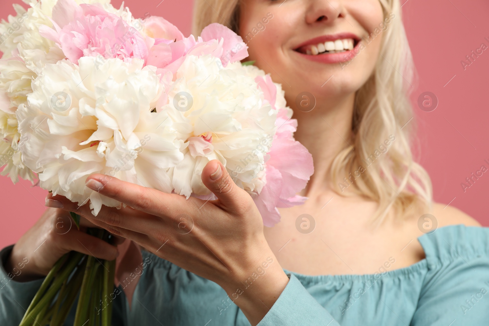 Photo of Woman with bouquet of beautiful peonies on pink background, closeup