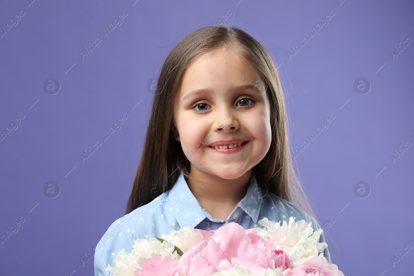 Photo of Cute little girl with bouquet of beautiful peonies on purple background