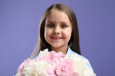 Photo of Cute little girl with bouquet of beautiful peonies on purple background