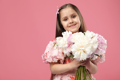 Photo of Cute little girl with bouquet of beautiful peonies on pink background, space for text