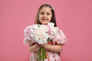 Photo of Cute little girl with bouquet of beautiful peonies on pink background