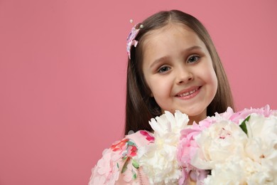 Photo of Cute little girl with bouquet of beautiful peonies on pink background, space for text