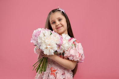 Photo of Cute little girl with bouquet of beautiful peonies on pink background