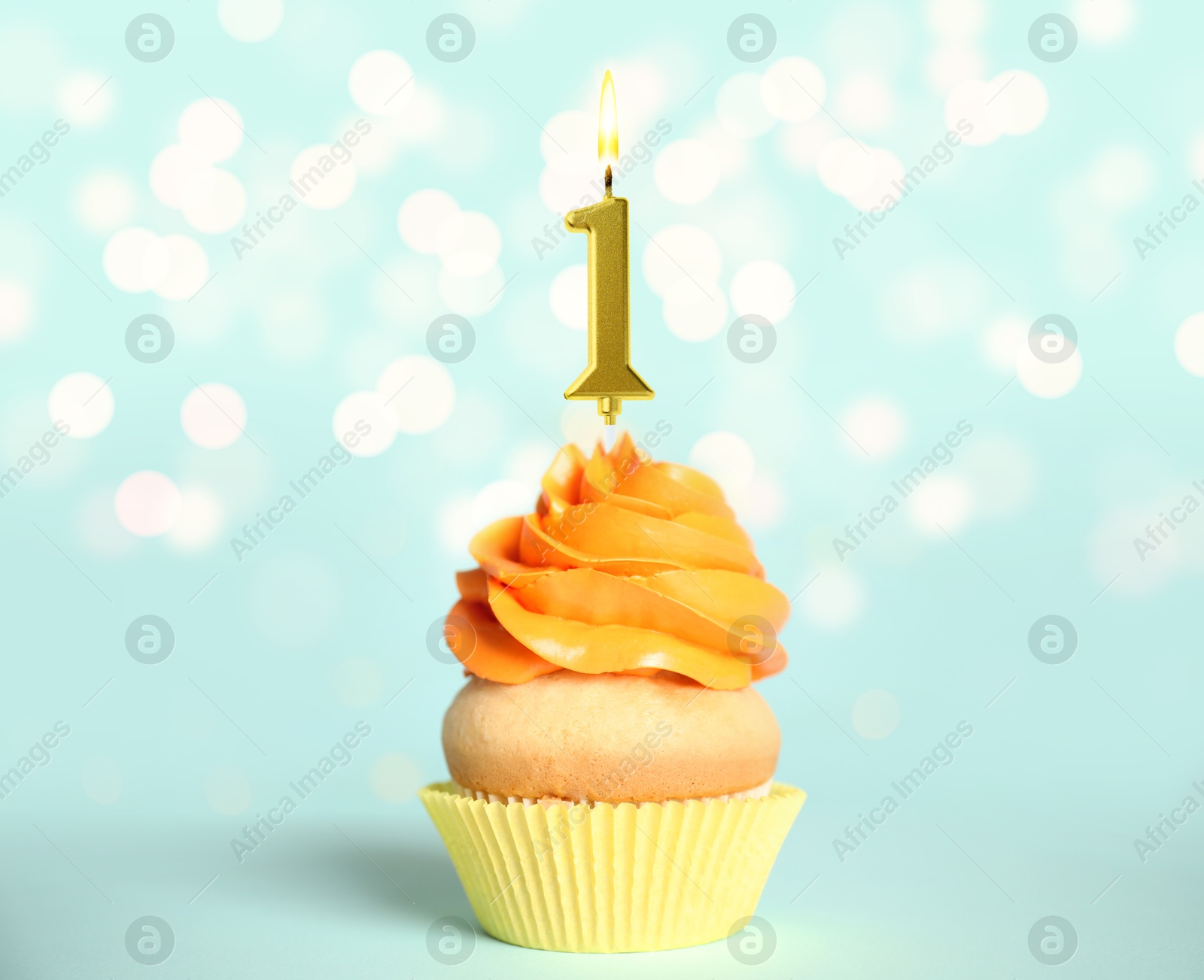 Image of Yummy cupcake with burning golden candle in shape of number 1 on light blue background with blurred lights. Birthday or other special occasion