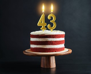 Image of Yummy cake with burning number shaped candles on black background. 43th birthday or other special occasion