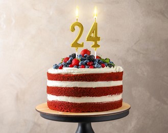 Image of Yummy cake with berries and burning number shaped candles on beige background. 24th birthday or other special occasion