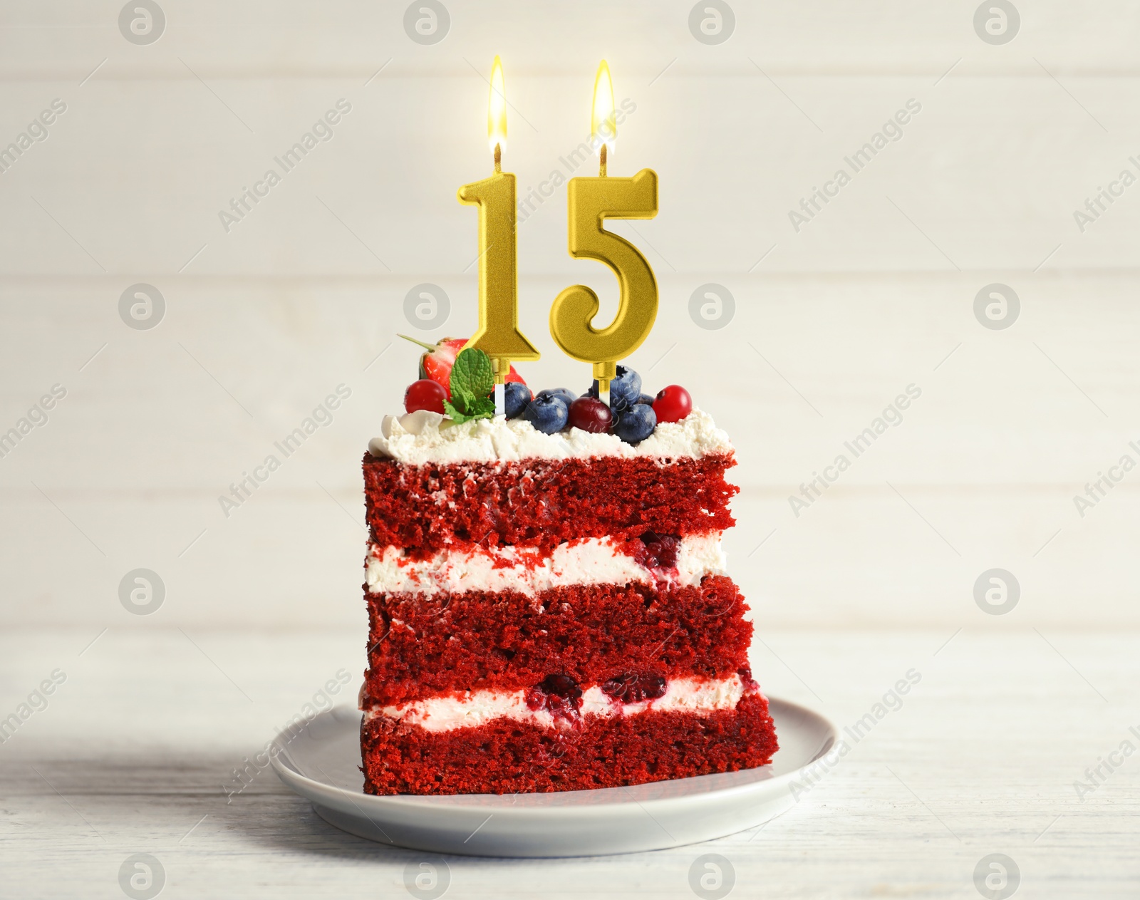 Piece of cake with berries and burning number shaped candles on white wooden table. 15th birthday or other special occasion Image of Piece of cake with berries and burning number shaped candles on white wooden table. 15th birthday or other special occasion