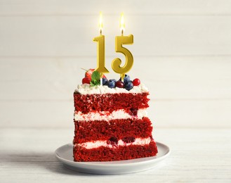 Image of Piece of cake with berries and burning number shaped candles on white wooden table. 15th birthday or other special occasion