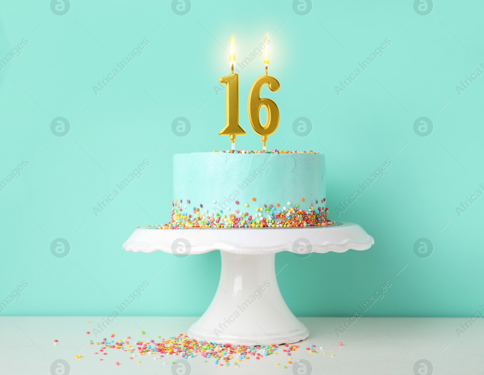 Yummy cake with burning number shaped candles and sprinkles on white table against turquoise background. 16th birthday or other special occasion Image of Yummy cake with burning number shaped candles and sprinkles on white table against turquoise background. 16th birthday or other special occasion