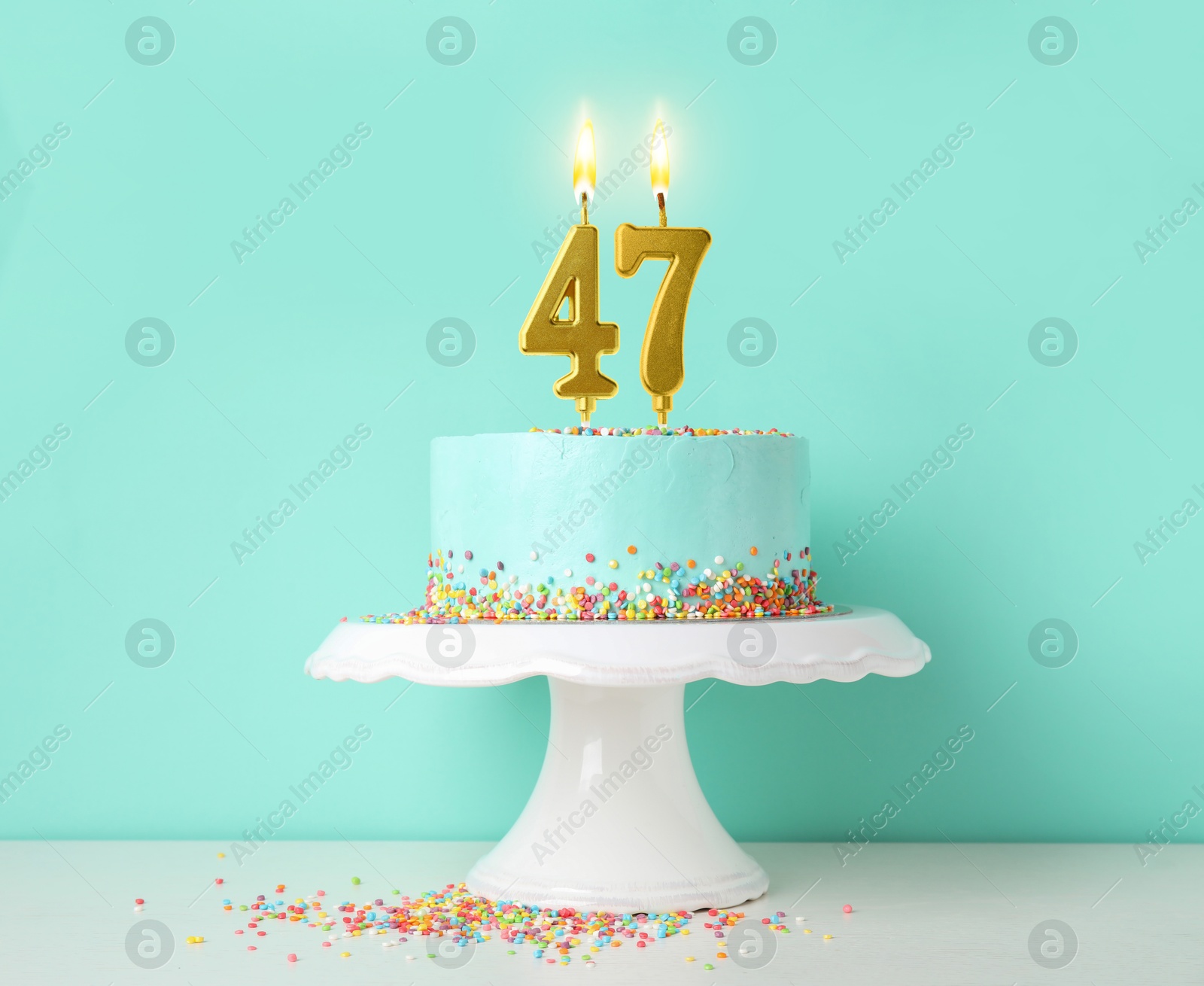 Yummy cake with burning number shaped candles and sprinkles on white table against turquoise background. 47th birthday or other special occasion Image of Yummy cake with burning number shaped candles and sprinkles on white table against turquoise background. 47th birthday or other special occasion