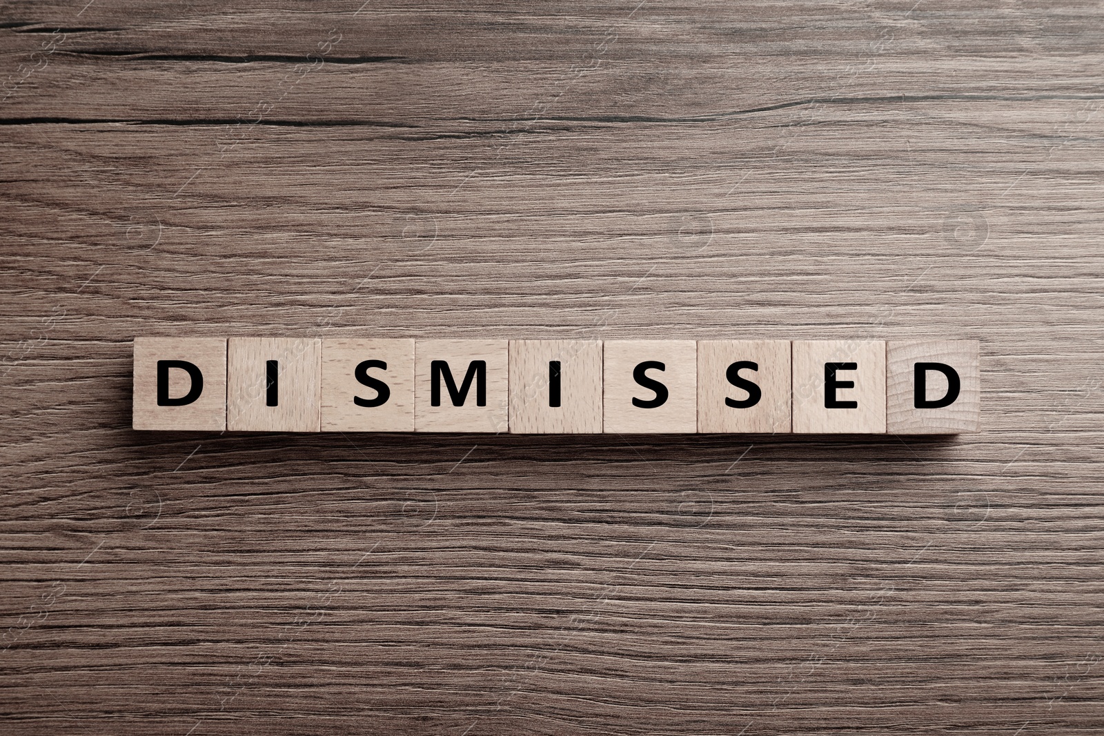 Image of Word Dismissed made of cubes on wooden background, top view