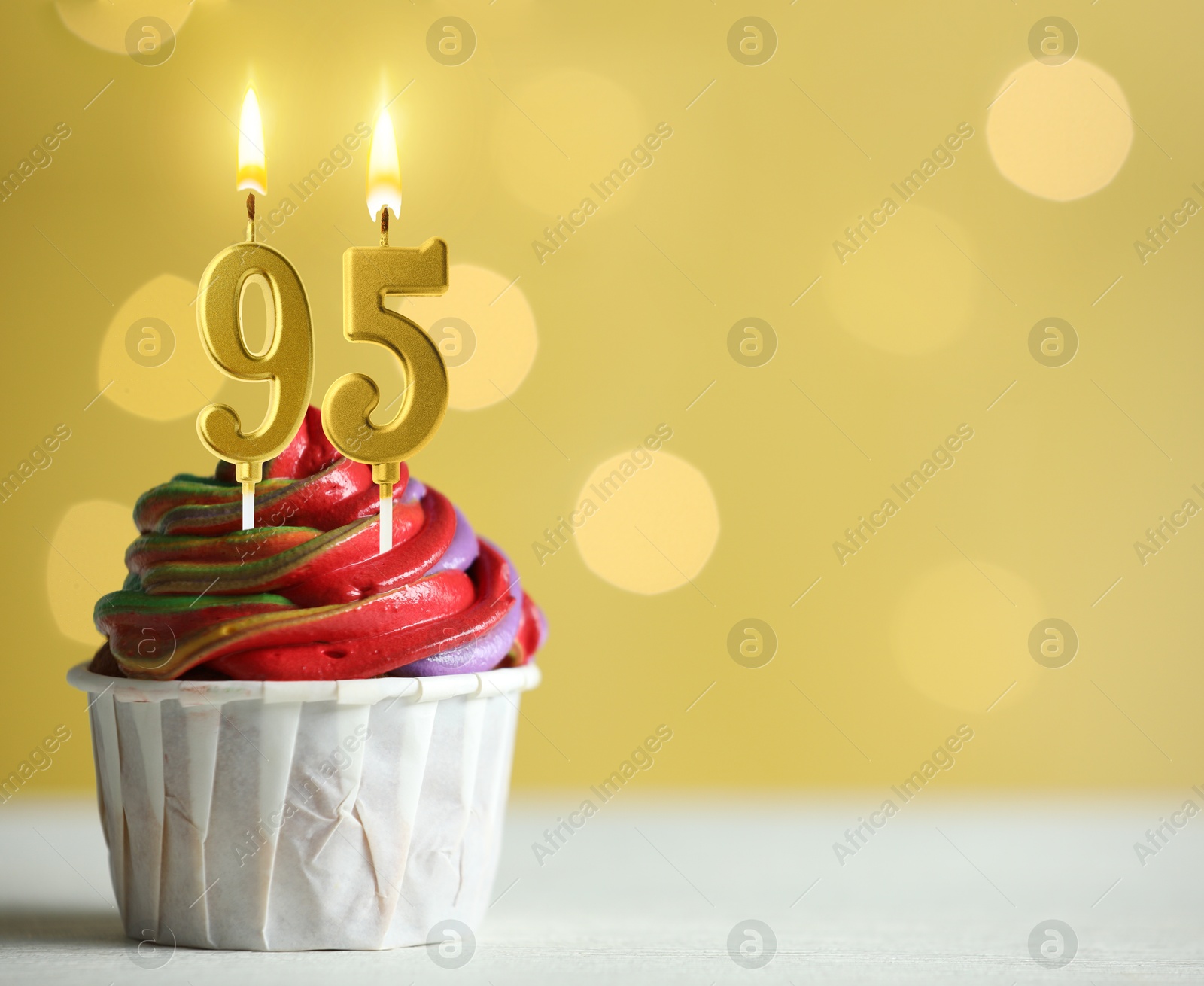 Yummy cupcake with burning number shaped candles on yellow background with blurred lights, space for text. 95th birthday or other special occasion Image of Yummy cupcake with burning number shaped candles on yellow background with blurred lights, space for text. 95th birthday or other special occasion
