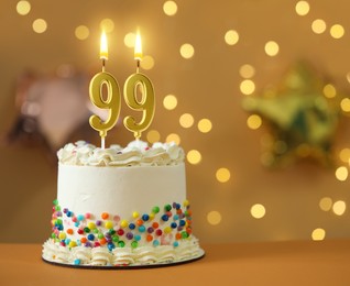 Image of Yummy cake with burning number shaped candles against blurred lights, space for text. 99th birthday or other special occasion