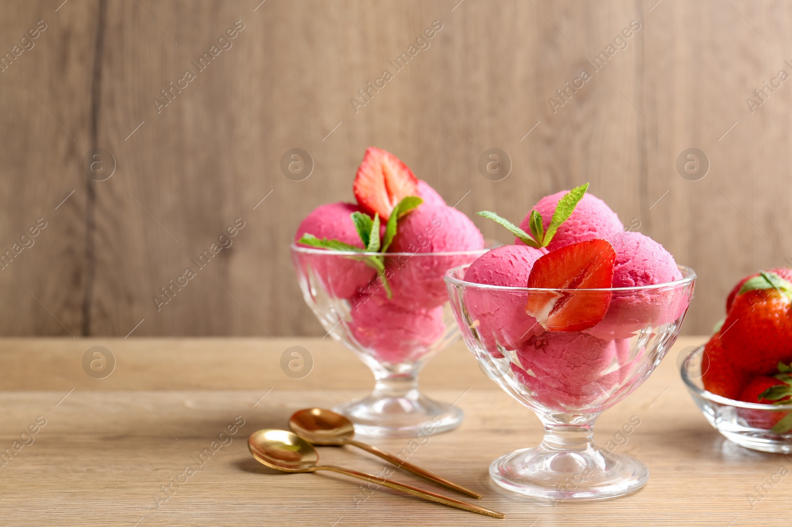 Refreshing sorbet, strawberries, mint and spoons on wooden table, closeup. Space for text Photo of Refreshing sorbet, strawberries, mint and spoons on wooden table, closeup. Space for text