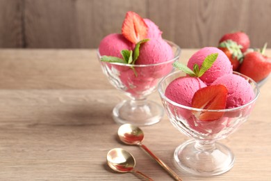Photo of Refreshing sorbet, strawberries, mint and spoons on wooden table, closeup. Space for text