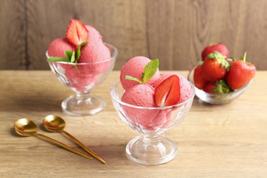 Photo of Refreshing sorbet, strawberries, mint and spoons on wooden table, closeup