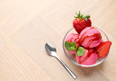 Photo of Refreshing sorbet with syrup, strawberries and mint in bowl on wooden table, above view. Space for text