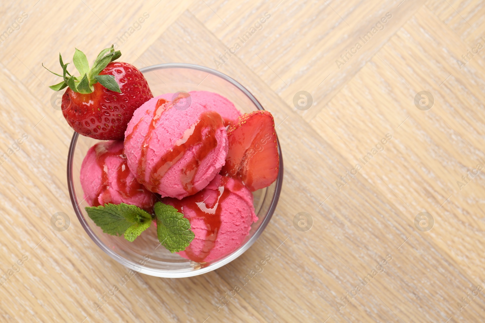 Refreshing sorbet with syrup, strawberries and mint in bowl on wooden table, top view. Space for text Photo of Refreshing sorbet with syrup, strawberries and mint in bowl on wooden table, top view. Space for text