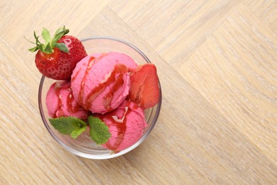 Photo of Refreshing sorbet with syrup, strawberries and mint in bowl on wooden table, top view. Space for text