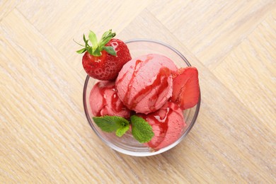 Photo of Refreshing sorbet with syrup, strawberries and mint in bowl on wooden table, top view